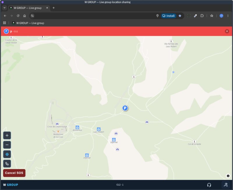 A laptop showing the W GROUP map of the Lacs Robert above Chamrousse, one walker as a single dot, and a red SOS alert bar across the top of the screen.