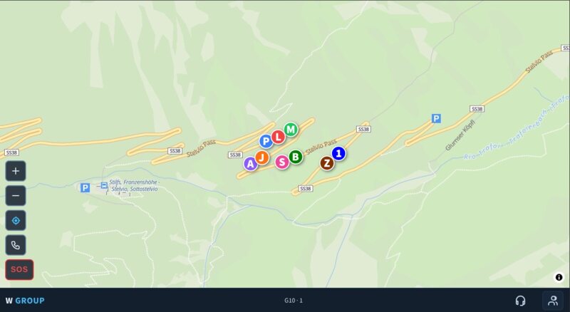 Nine cyclists as coloured dots bunched together at the foot of the Stelvio pass.